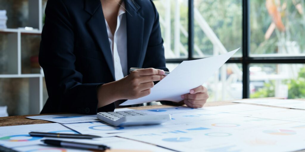 Geschäftsfrau analysiert Finanzberichte am Arbeitsplatz.